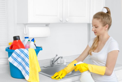 Cleaner tidying a modern Clapham flat kitchen and living area