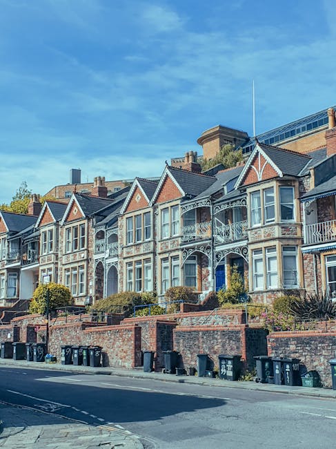 A row of Victorian-style residential houses in Clapham, Lambeth, characterized by ornate white detailing on brick facades, bay windows, and small front gardens with shrubs. The buildings are multi-sto
